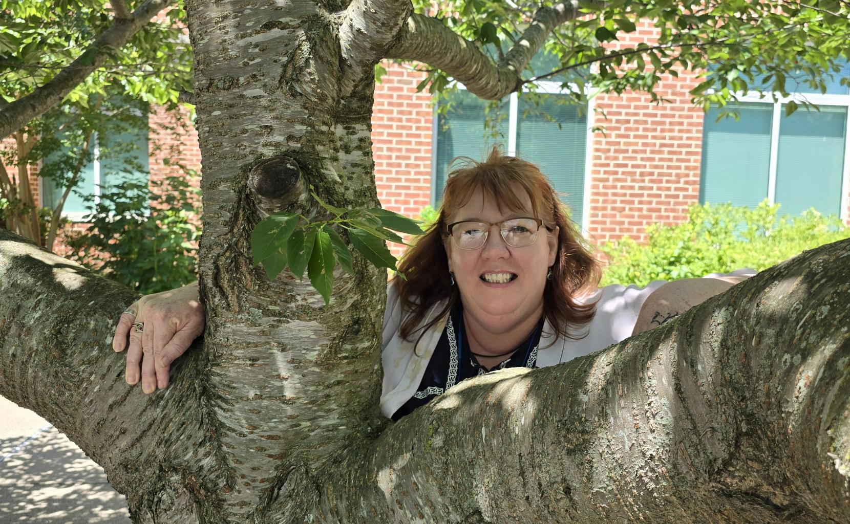 Bonni Miller leans on a tree on Salisbury University's campus