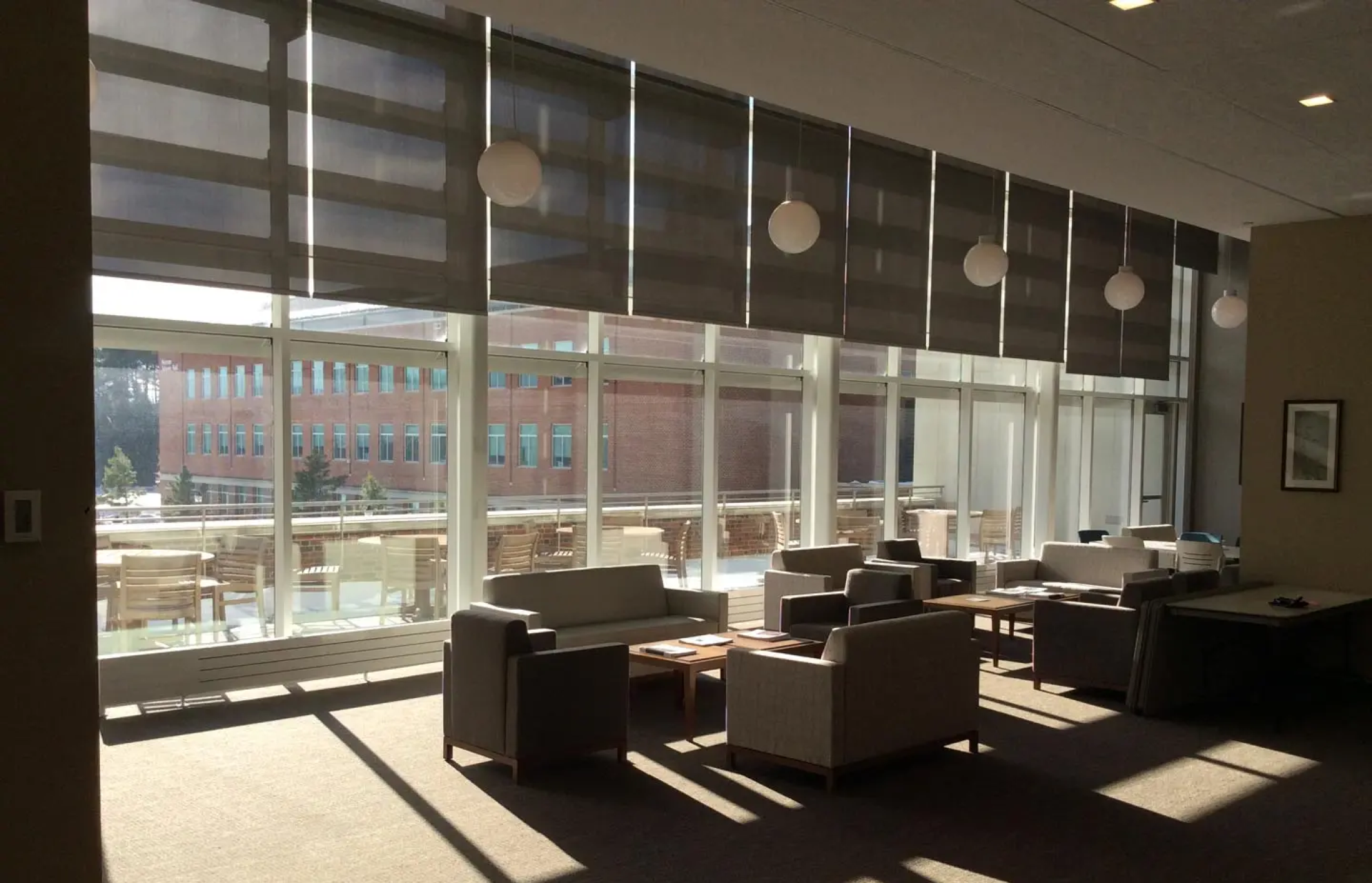 Tables and chairs arranged by windows in the faculty lounge