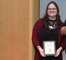 Haley Cristea holding a plaque of recognition