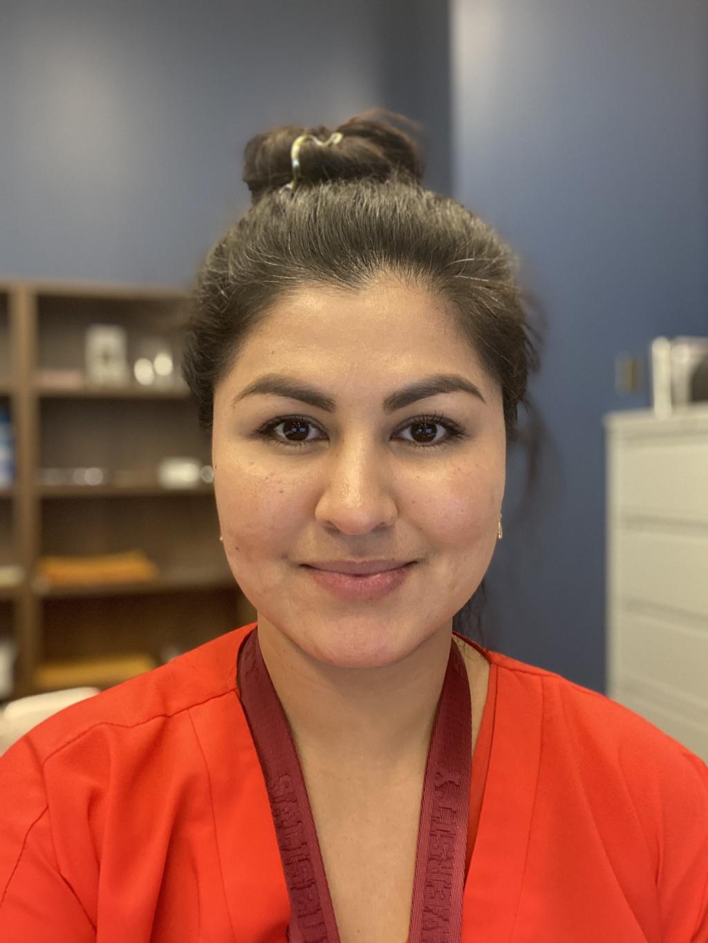 Sara Prebenda outdoors rocking a floral dress, sunglasses, and a friendly smile.