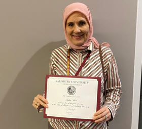 Safaa Said holding a certificate of recognition