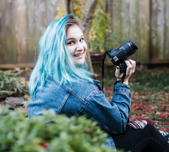 Portrait of Sam Gordy holding a camera