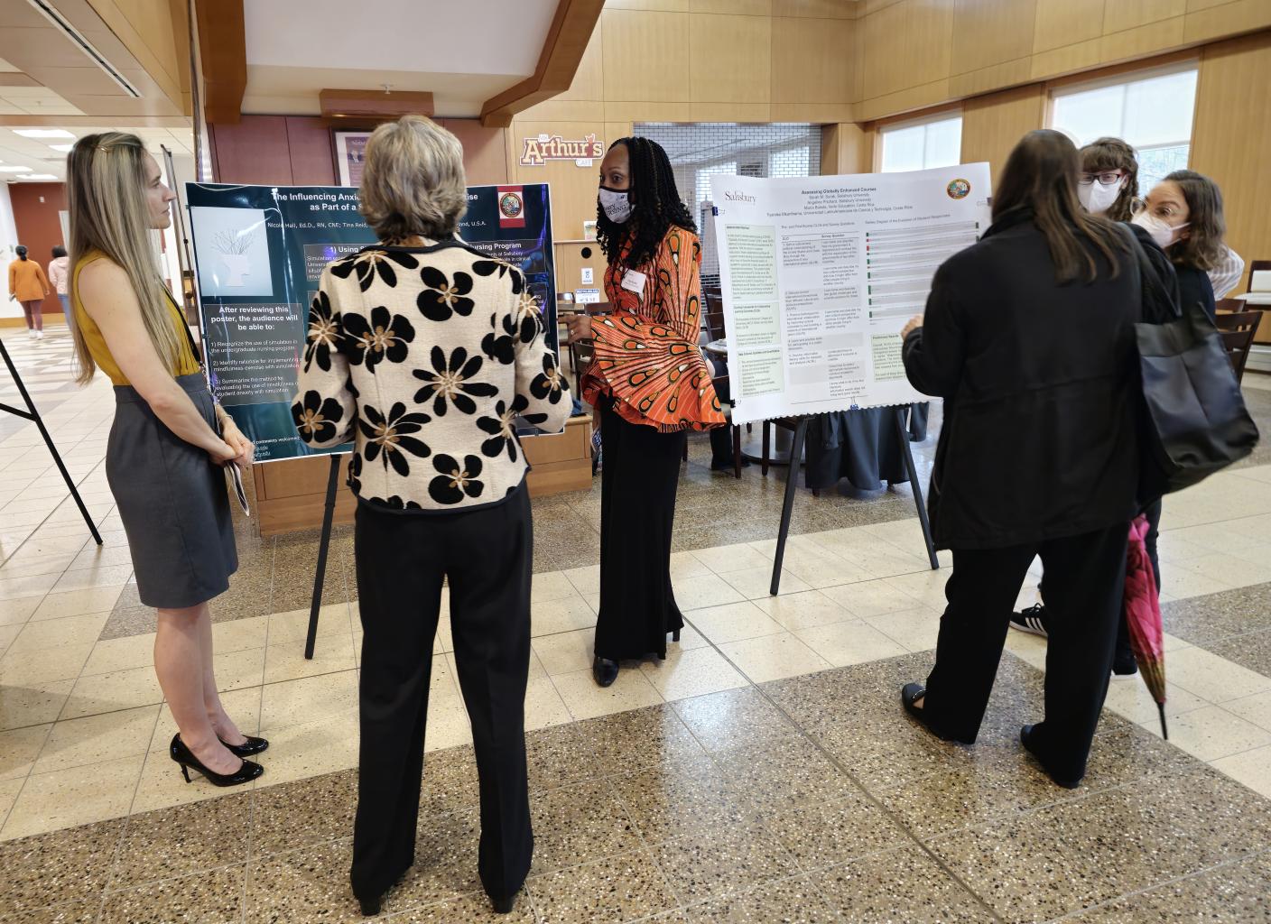 Six Teaching & Learning Conference participants discuss posters during the lunchtime poster session. 