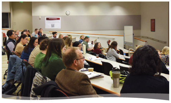 A group of TLC attendees seated in PH 156 watching a presenter who is off screen.