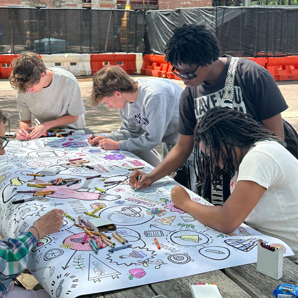 Employees and Students Coloring a Centennial Banner