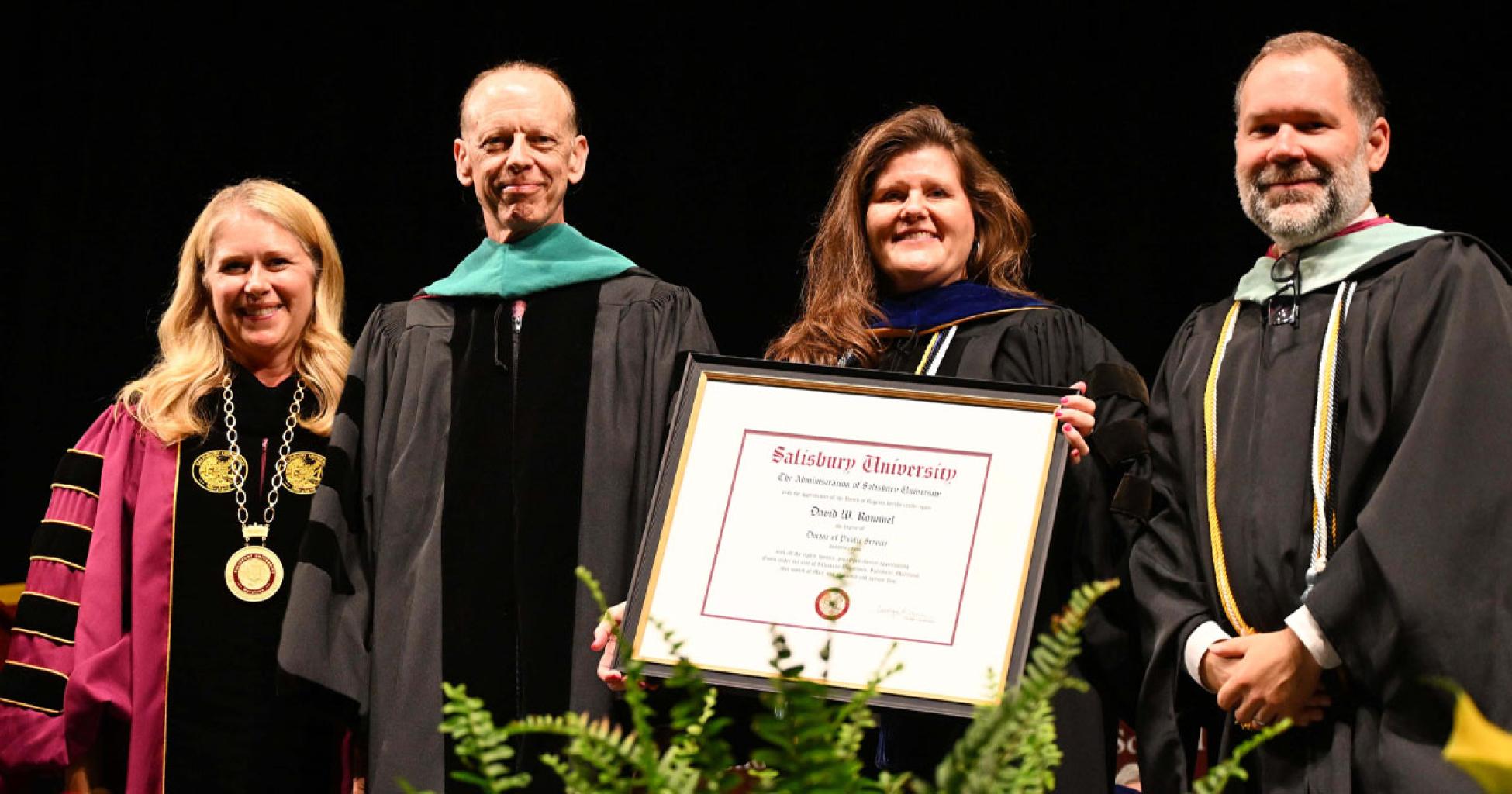 Entrepreneur and philanthropist Dave Rommel received an honorary doctorate from Salisbury University during SU's annual Spring Commencement. Pictured, from left: SU President Carolyn Ringer Lepre; Rommel; Dr. Christy Weer, dean of SU's Franklin P. Perdue School of Business; and Jason Curtin, SU vice president of advancement and executive director of the Salisbury University Foundation, Inc.